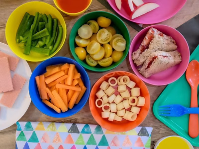 Party Kit displayed with reusable plastic bowls of many colors filled with food.
