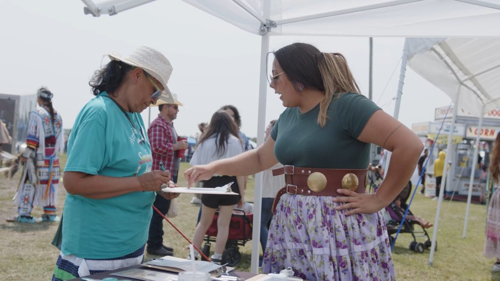 A native woman from North Dakota Native vote recruiting new electric cooperative members to join the energy task force at the Spriit Lake powWow